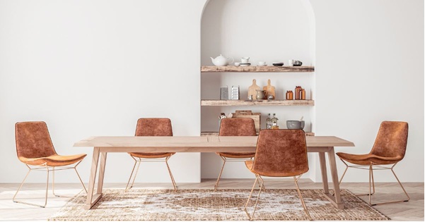 Two young ladies talking one holding a book another with box in a collge dorm